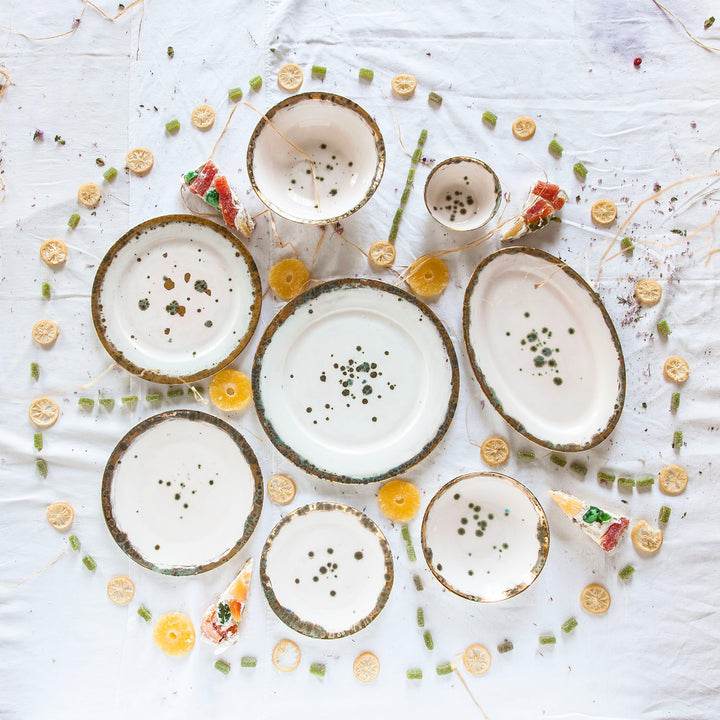 Rustic ceramic plates with organic elements on white background setting.