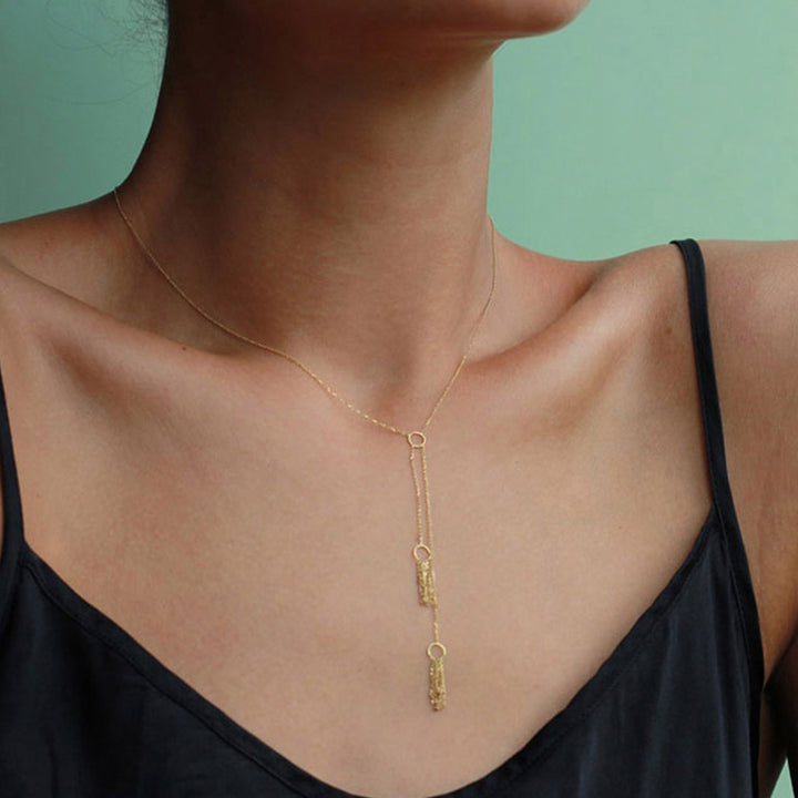 Close-up of elegant gold necklace with geometric pendant design