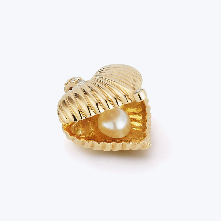 Gold seashell ring with pearl and diamond accents, elegant design.