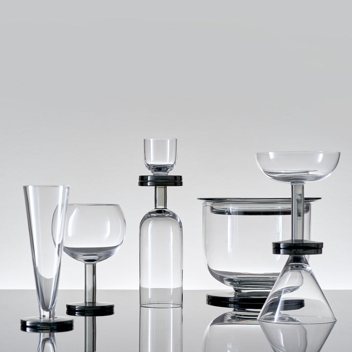 Assortment of glassware arranged artistically on reflective grey background.