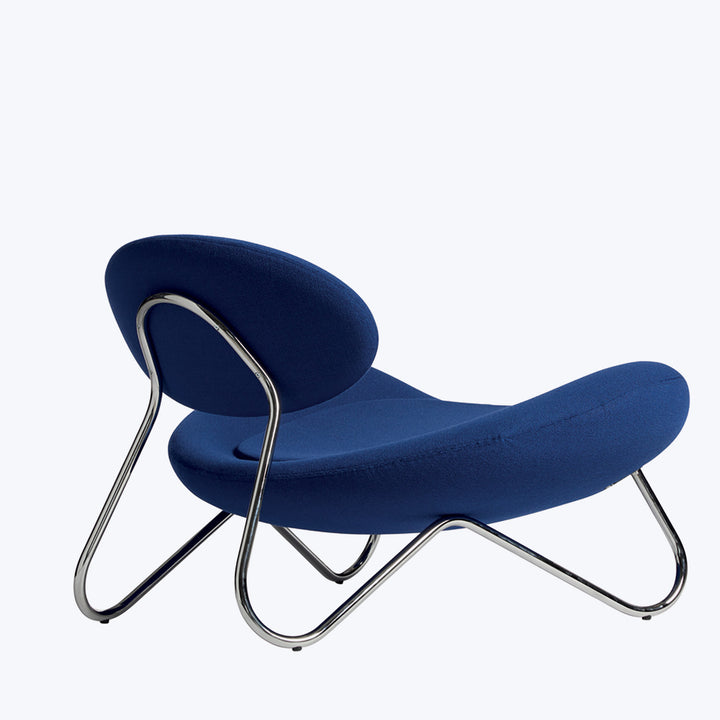 Modern lounge chair with elegant design, dark blue upholstery, chrome frame.