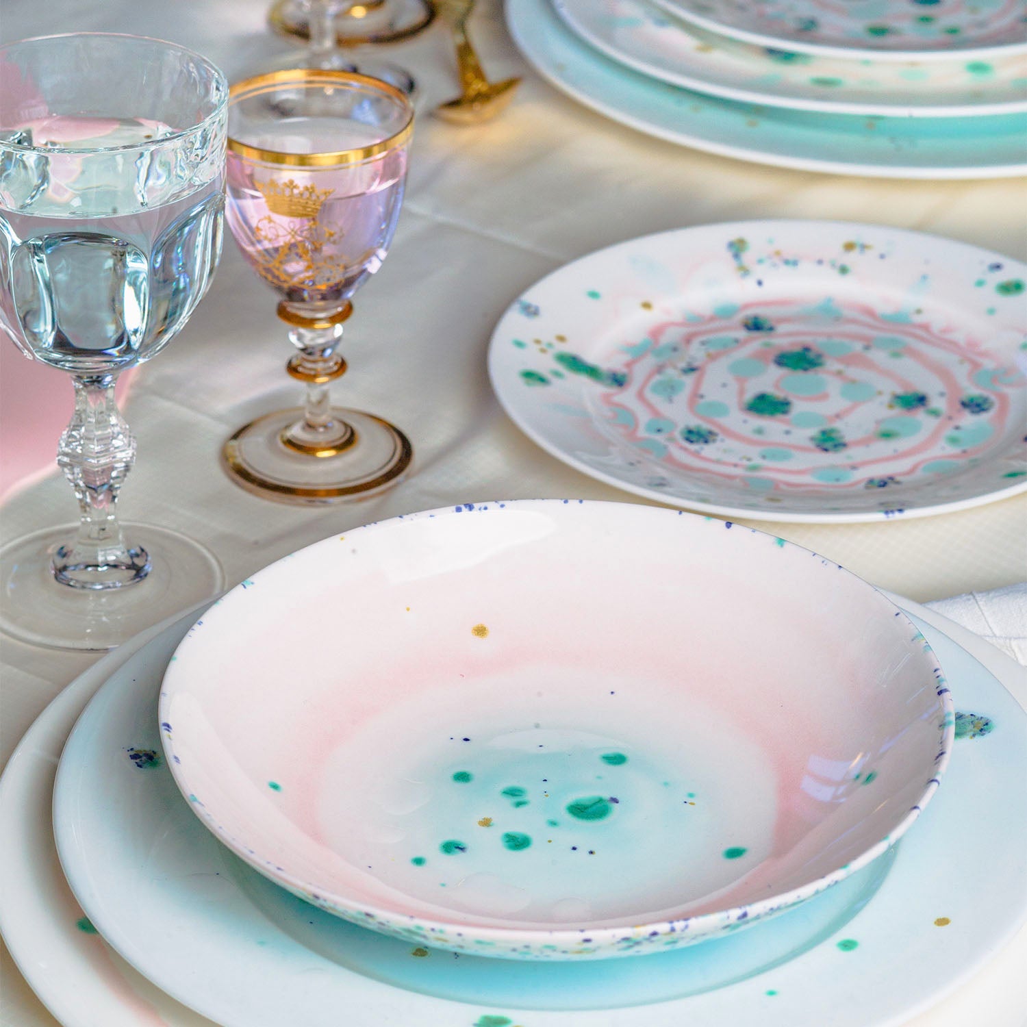 Elegantly set table with unique ceramic dishes and glassware.