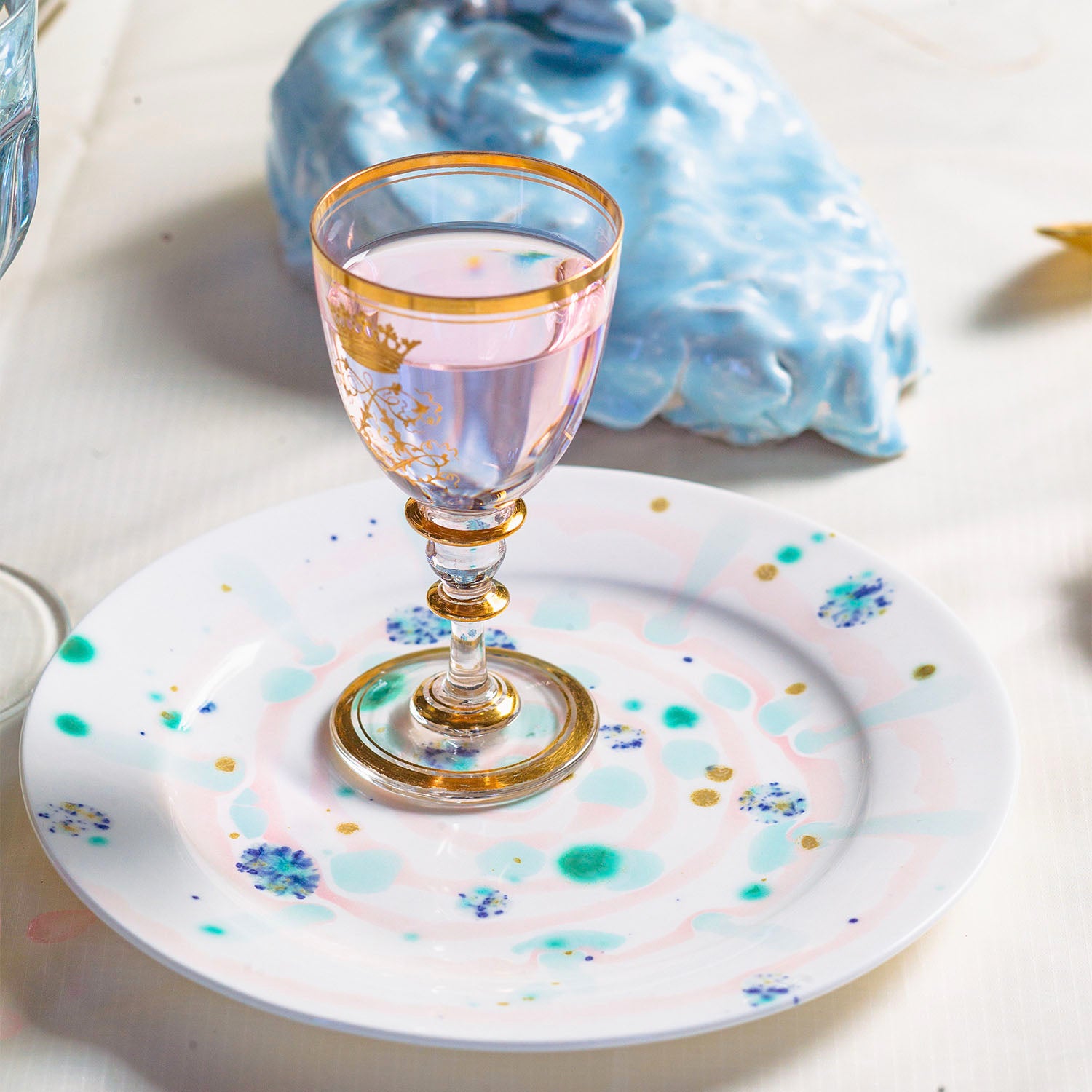 Elegant glassware and whimsical plate create artistic table setting.