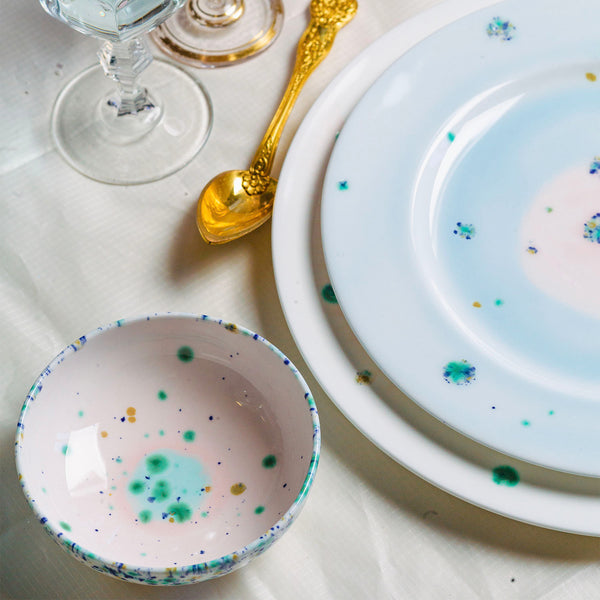 Elegant table setting with gold spoon, glass, and blue accents.