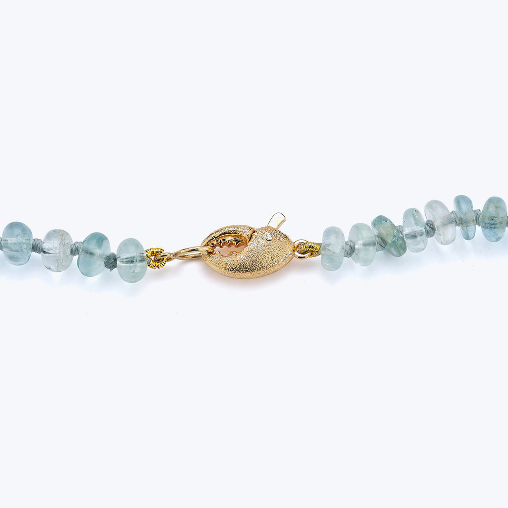 Translucent blue bead bracelet with textured gold clasp, elegant design