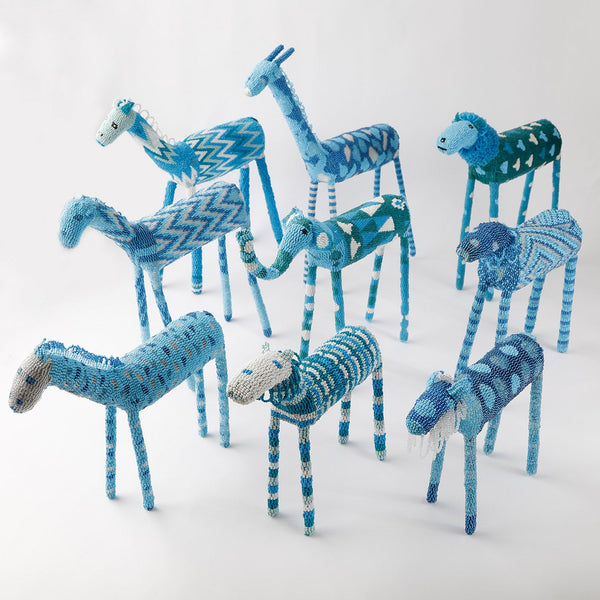 Colorful handcrafted animal figures in blue and white knit fabric.