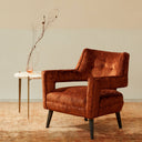 Mid-century modern armchair with burnt orange upholstery and minimalist decor.