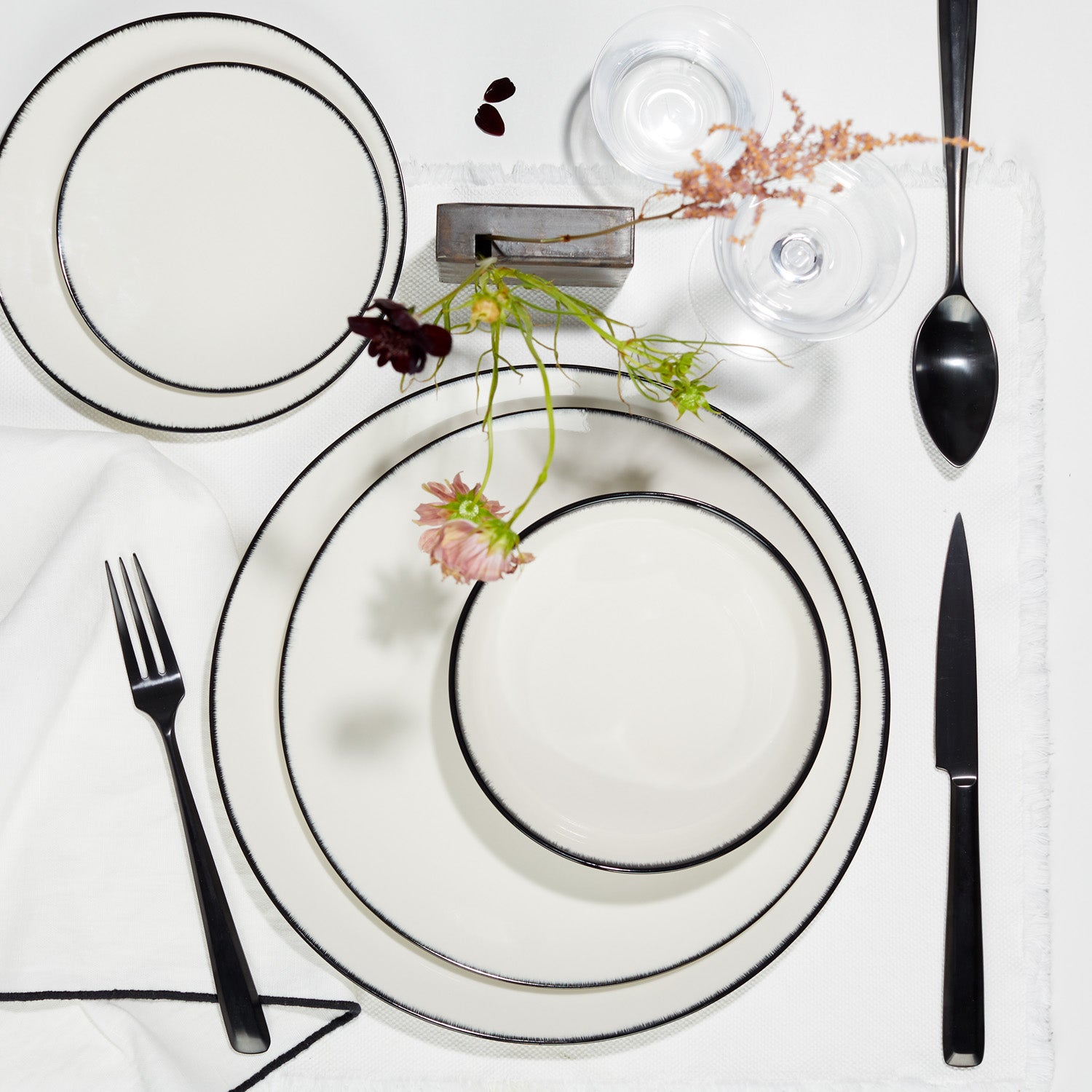 Modern and elegant table setting with minimalist black utensils.