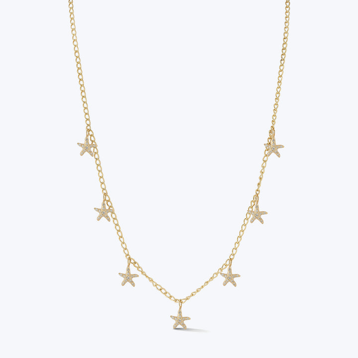 Delicate gold necklace with star pendants on white background.