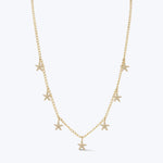 Delicate gold necklace with star pendants on white background.